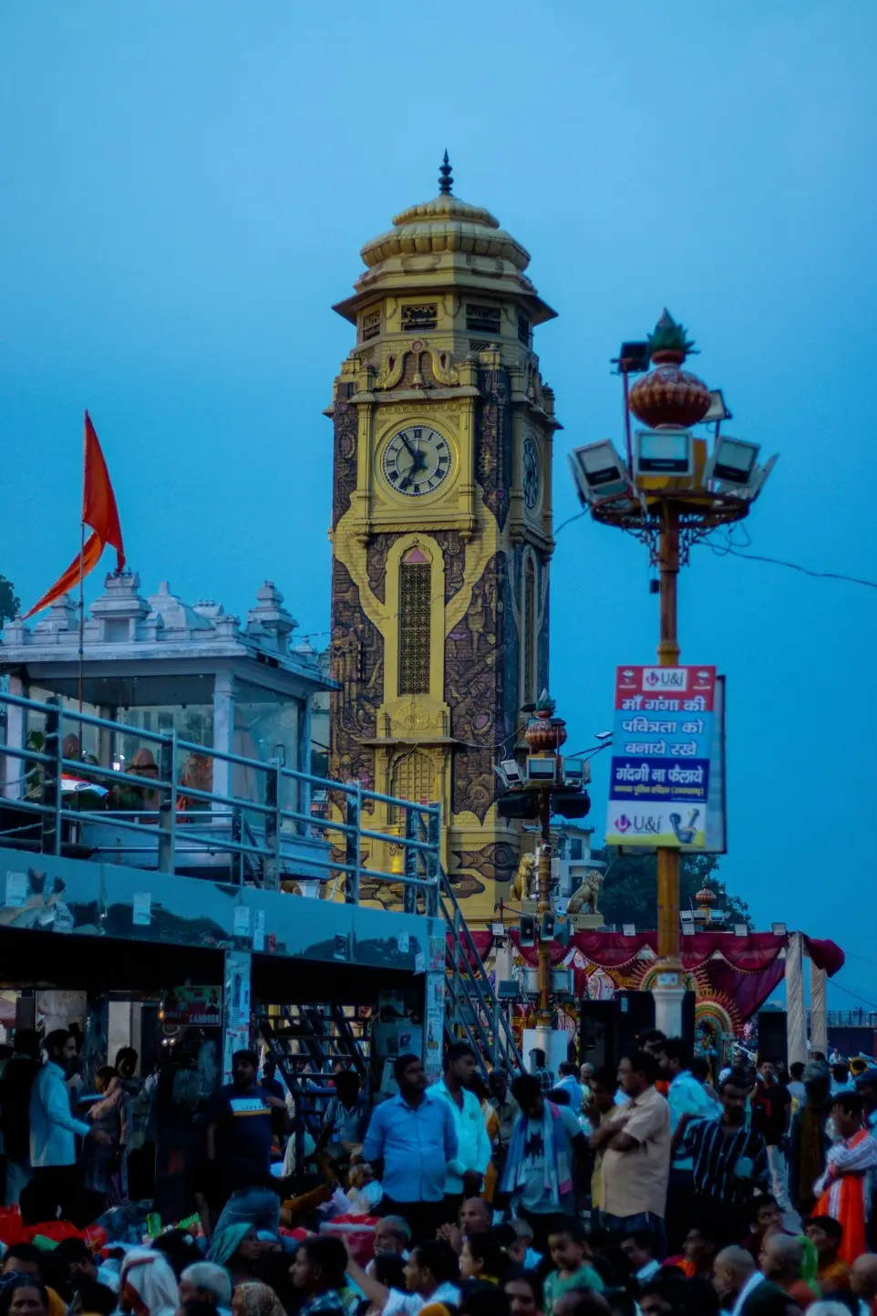 A crowd of people standing around a tall clock tower